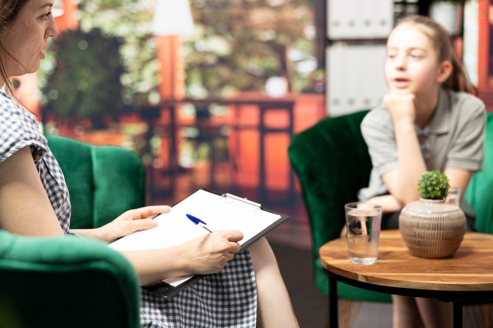A child and parent sitting close together on a couch, working through a difficult moment.