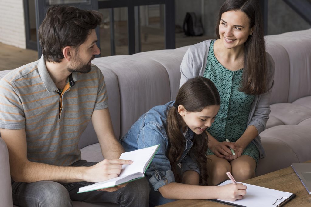 A parent and child sitting together at a table, working through something quietly and patiently — the kind of ordinary moment where family patterns start to change.