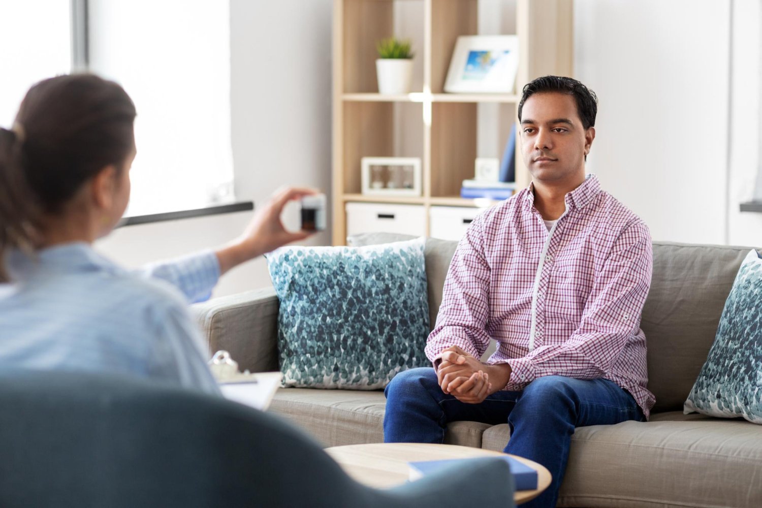 A therapist guiding a client through an EMDR eye-movement exercise in a private office.