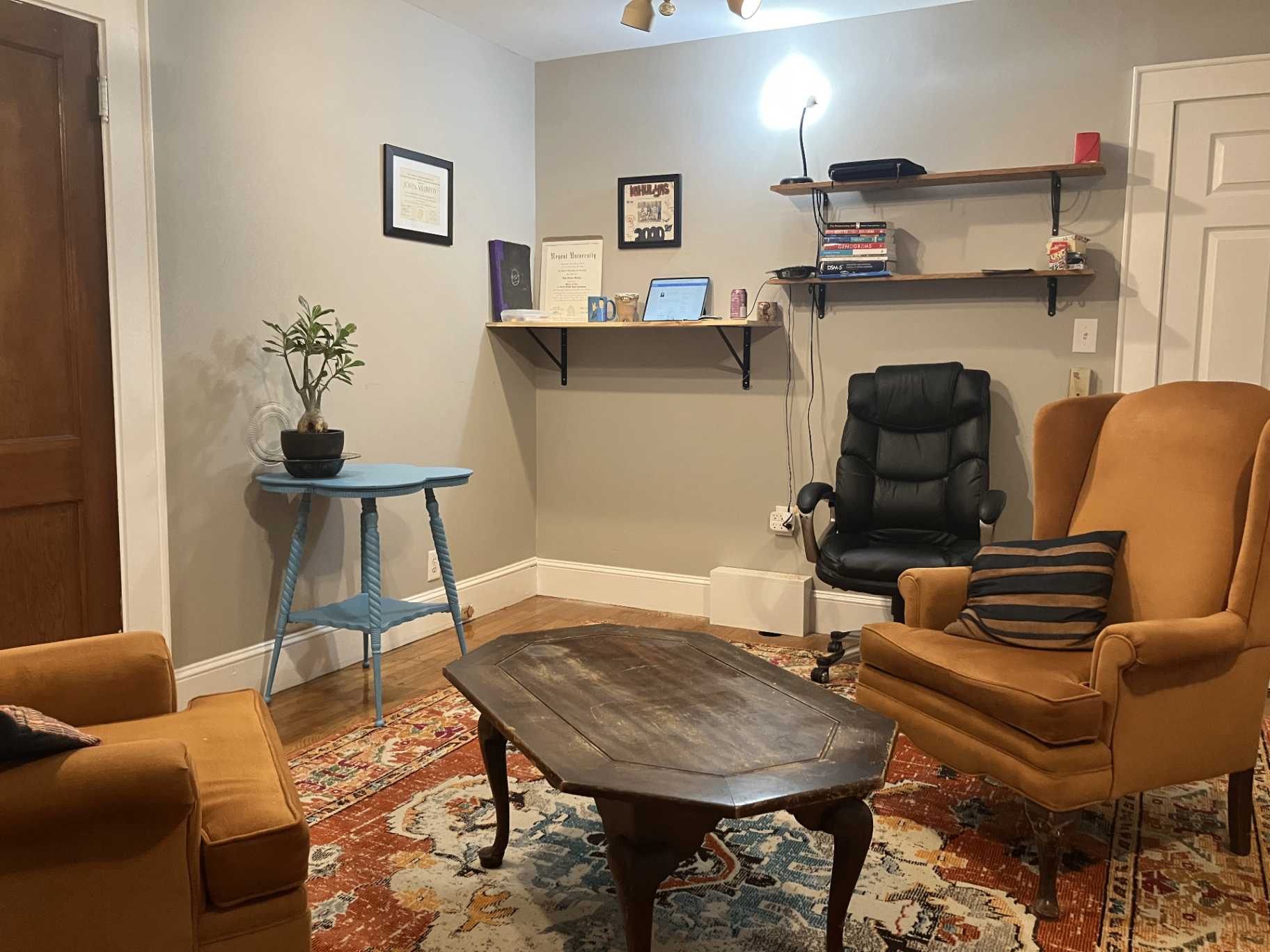 A warm, sunlit therapy office in Siler City, NC with two mustard-yellow armchairs and a wooden coffee table.